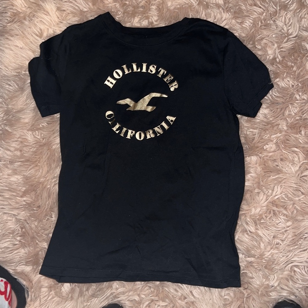 A black hollister shirt fitted comfortable with gold lettering on it